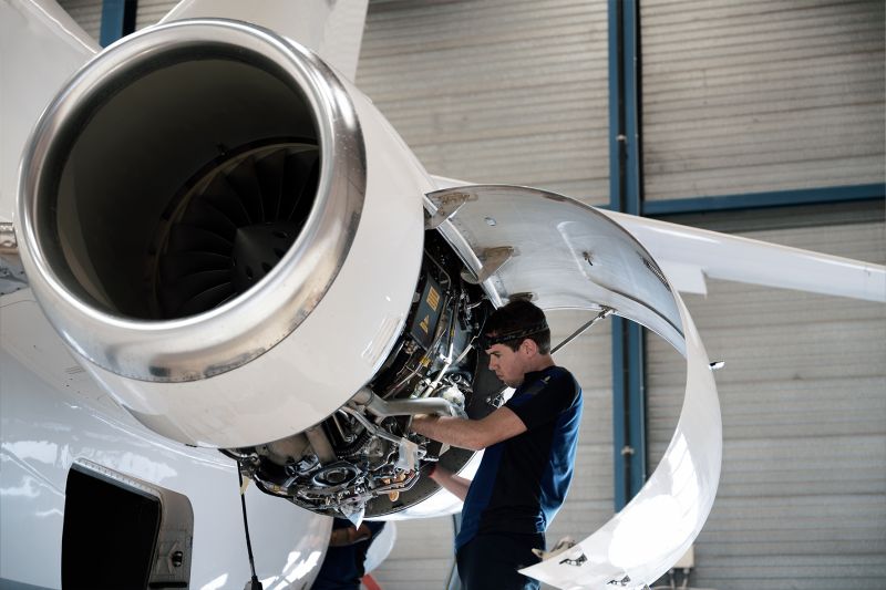 Motor turbofan de avião a jato sendo inspecionado no hangar