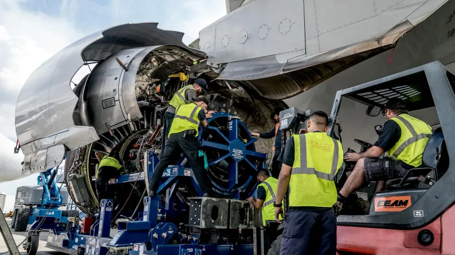 Equipe de manutenção fazendo a troca de um motor turbofan na rampa