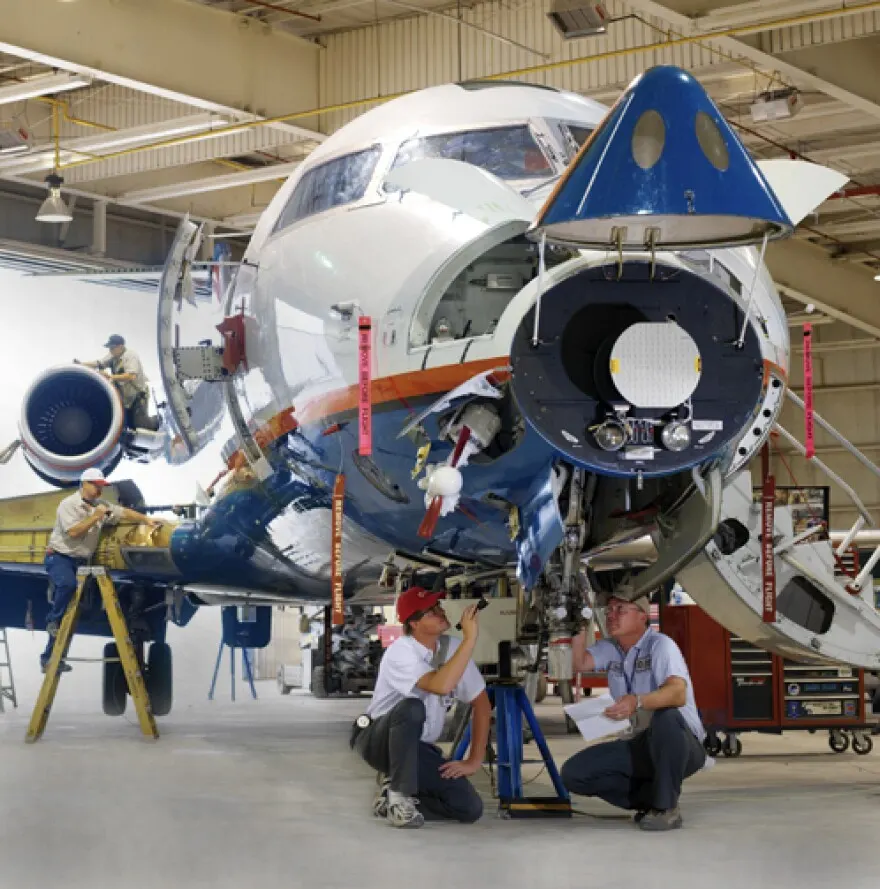 Aeronave em manutenção pesada com o radome aberto e equipe trabalhando
