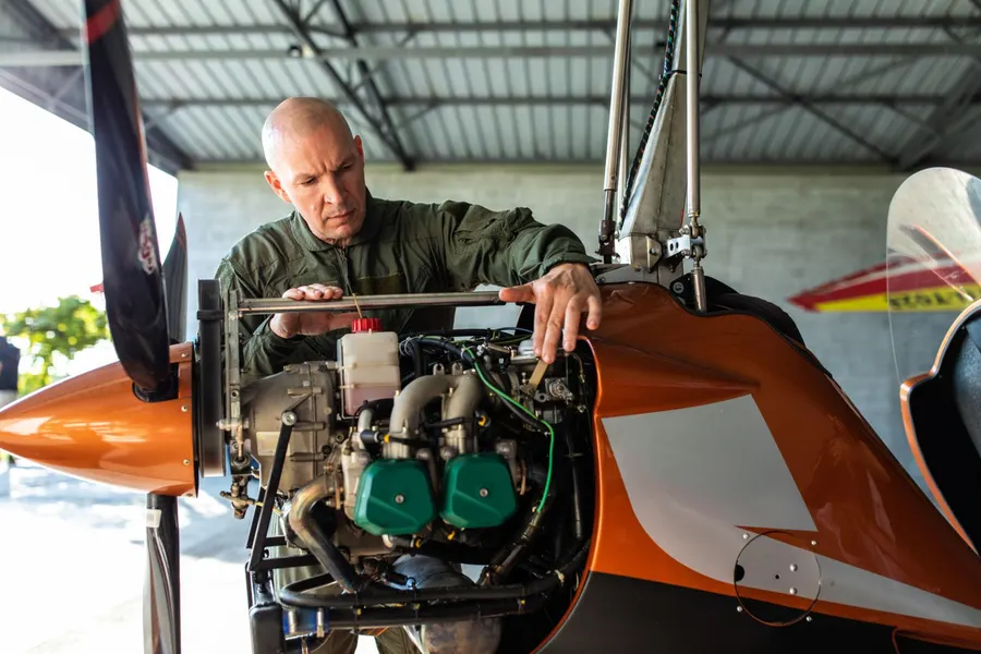 Mecânico de manutenção aeronáutica trabalhando em um motor Rotax de girocóptero