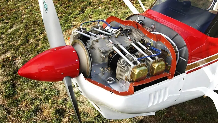 Motor a pistão boxer de um monomotor com o capô aberto na oficina
